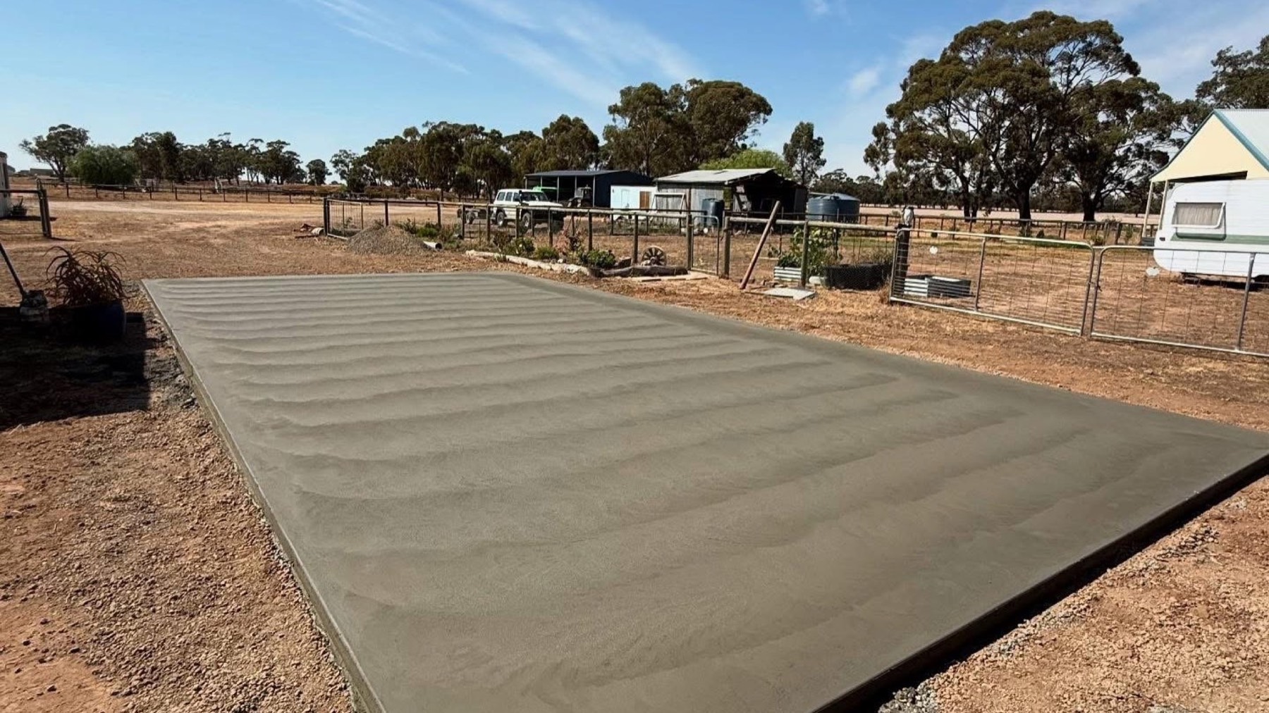 A large concrete slab poured on an open block with box-ironbark gums behind