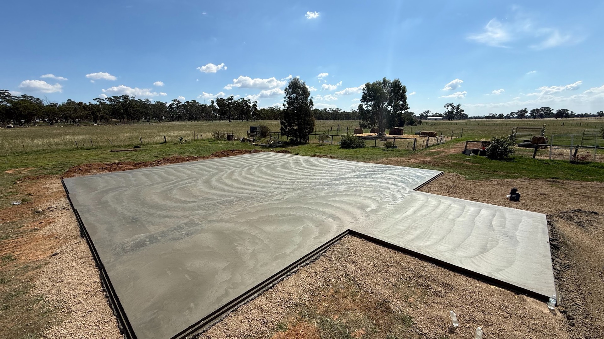 A large concrete slab poured on an open rural block under a wide sky