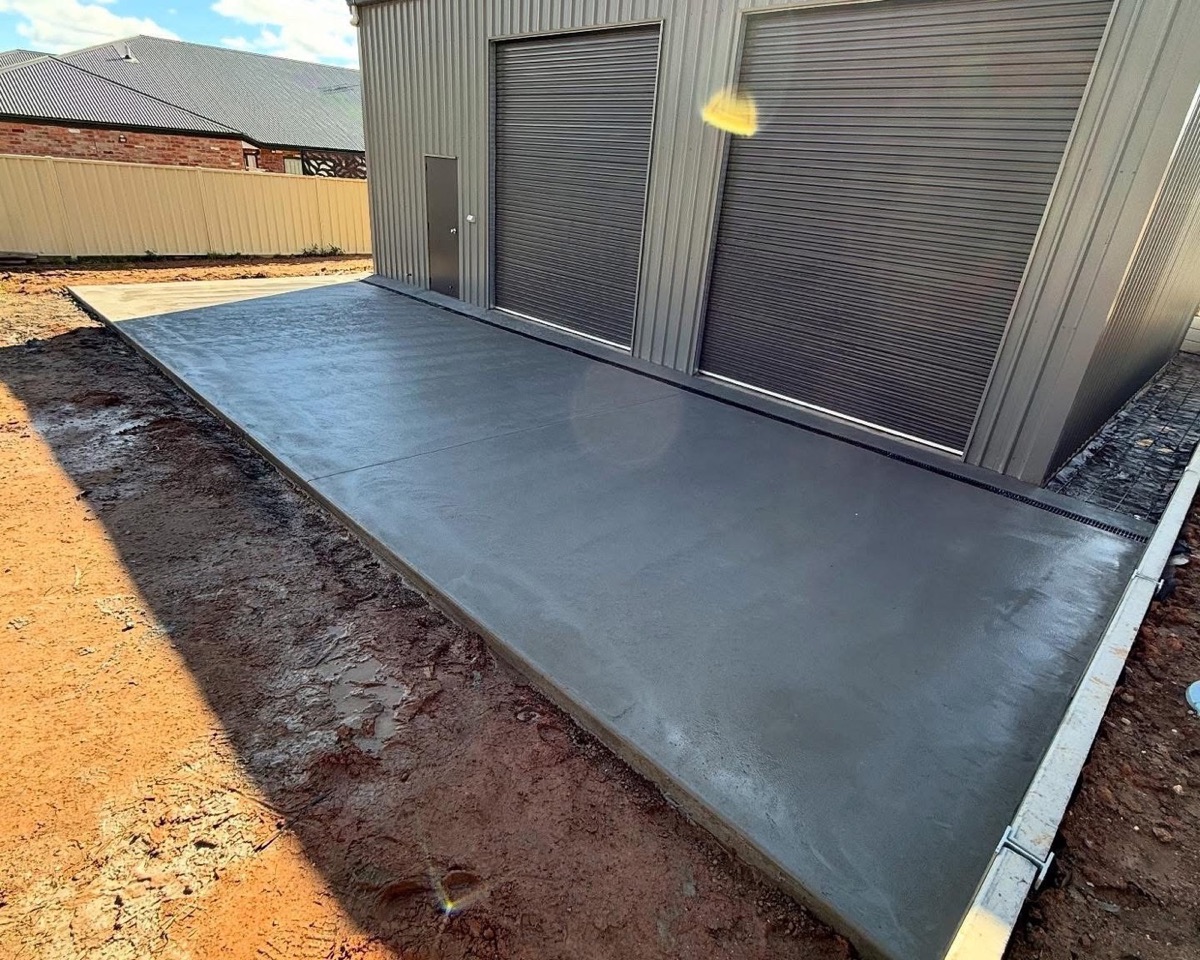 A finished shed pad formed and poured on a levelled block of orange earth