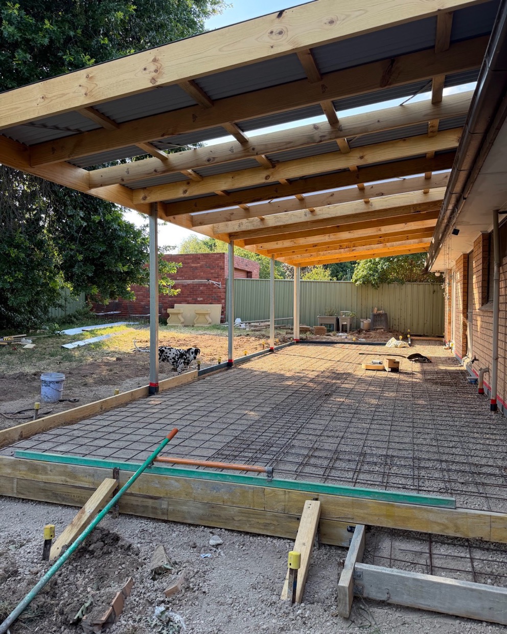 Formwork and steel mesh set out over a prepared base before a pour
