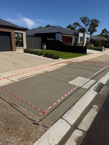 A new concrete driveway and crossover meeting the street kerb