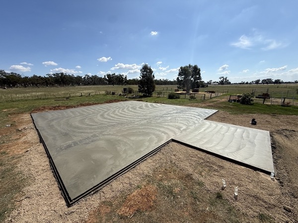 A large concrete slab poured on an open rural block under a wide sky