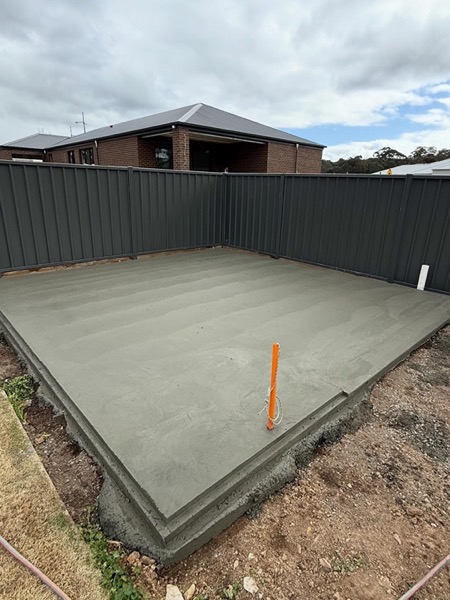 A finished shed pad formed and poured inside a Colorbond fence line