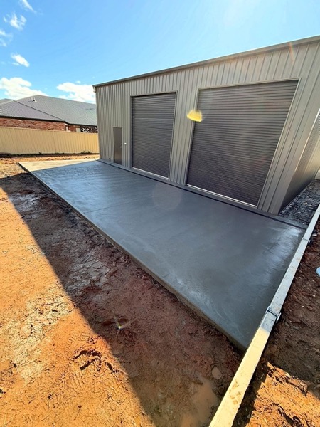 A finished shed pad poured on a levelled block of orange earth