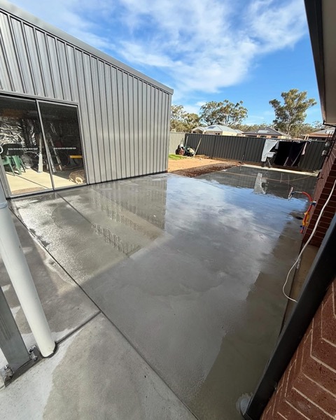 A concrete apron poured up to the roller doors of a shed