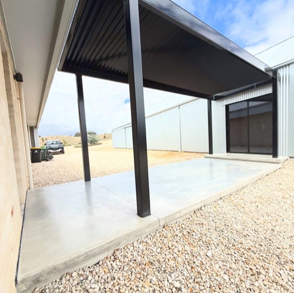 A finished alfresco slab under a carport roof looking out to the yard