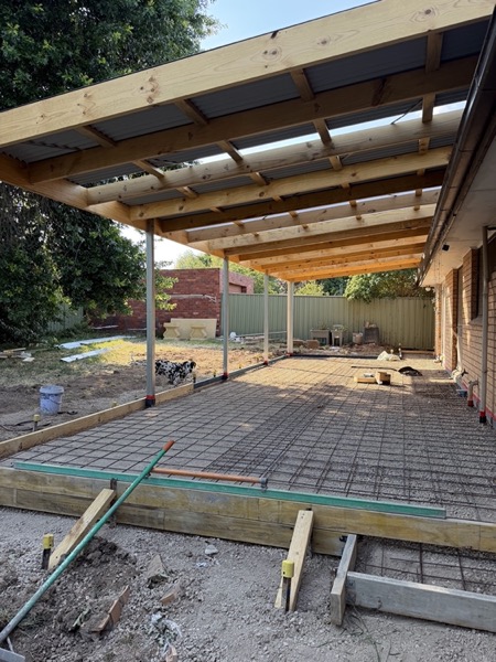Formwork and steel mesh set out over a prepared base before a pour