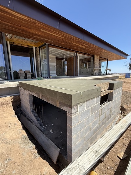 A blockwork structure sitting on a poured slab on a building site